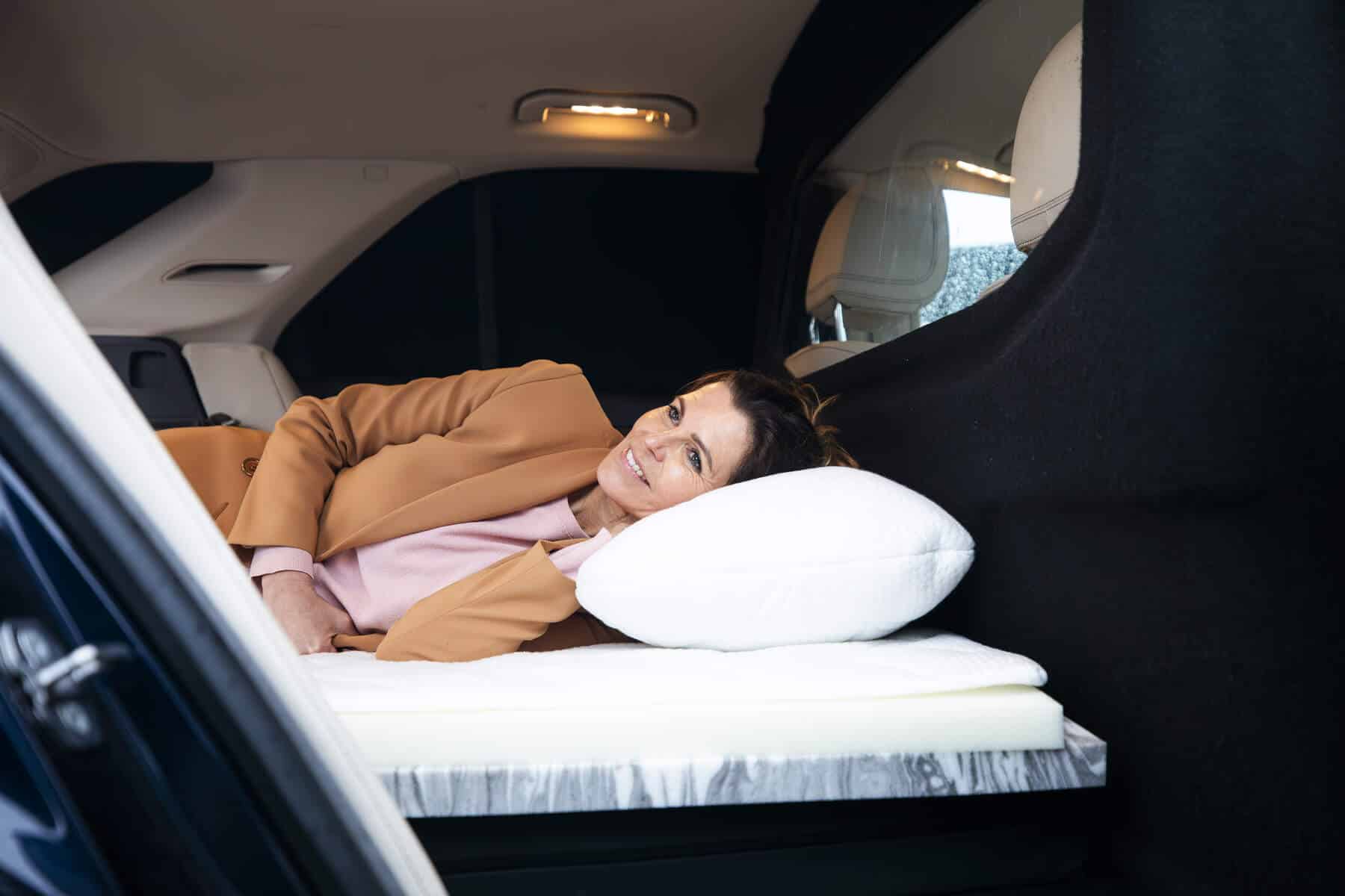 Vrouw ligt op een op maat gemaakt vouwwagen matras